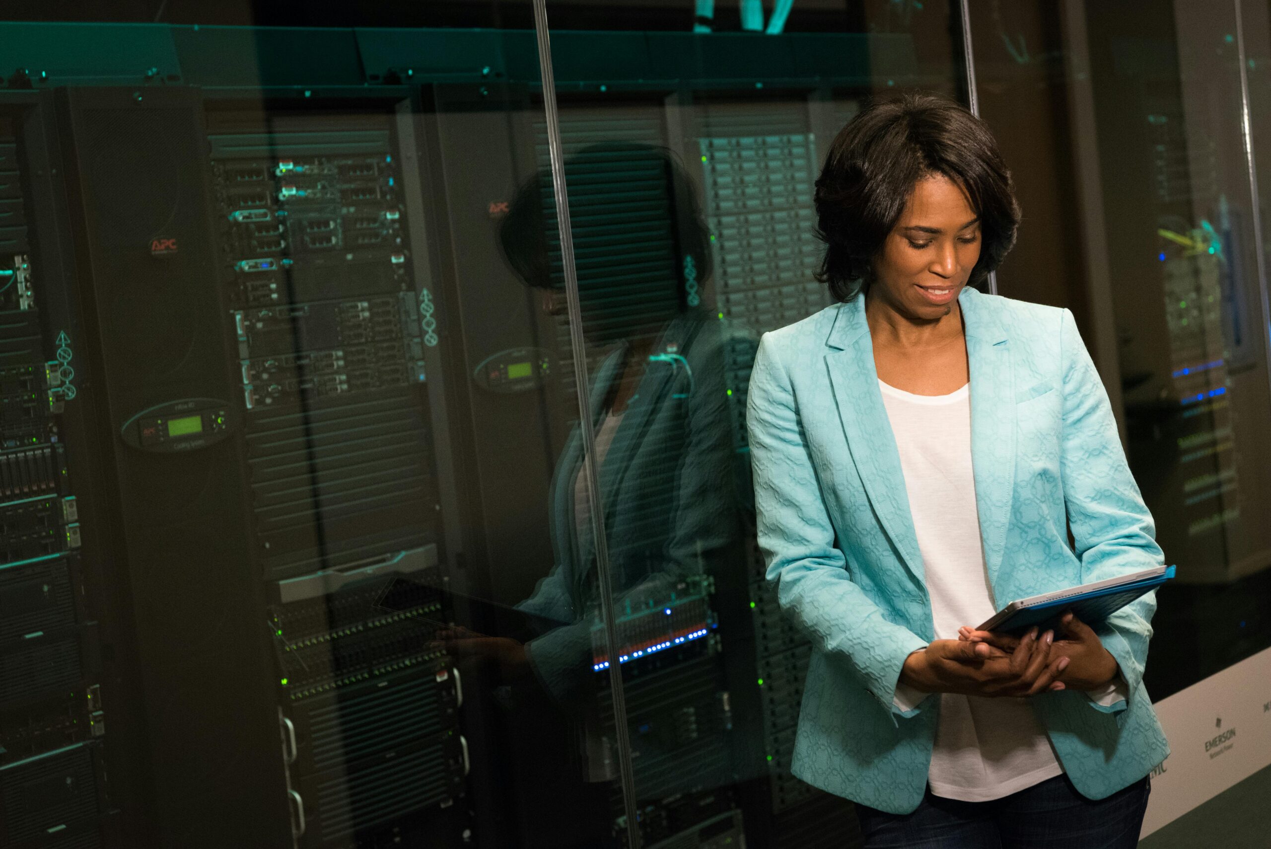 Female IT professional examining data servers in a modern data center setting.